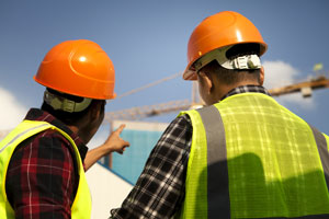 Two men in safety vests working in a construction zone
