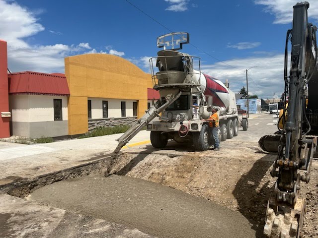 Pouring concrete into a hole on a road