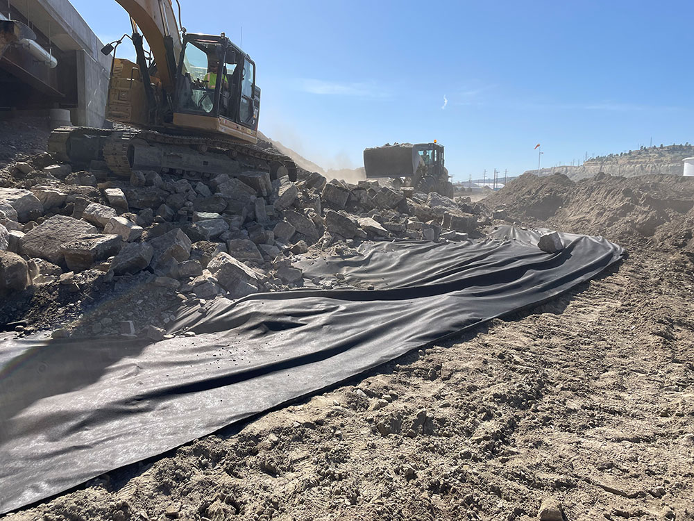 To help protect the riverbank, Riverside Contracting is installing riprap, or large rock, around the west side of the Yellowstone River Bridge. The fabric placed under the riprap helps to stabilize the rock.
