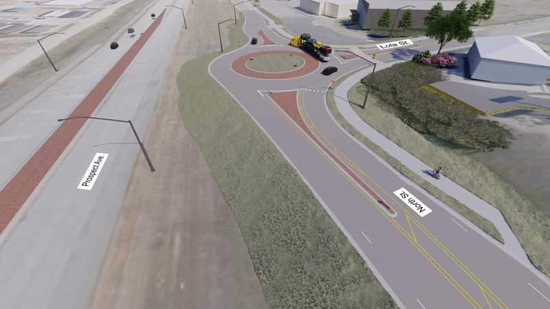 Image depicts new single lane roundabout at the Lola Street/North Street-Tricia Street intersection. A semitruck is navigating the roundabout in the image.
